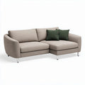 L-shaped sectional sofa in light beige fabric with two green accent pillows 200 x 90 x 85cm